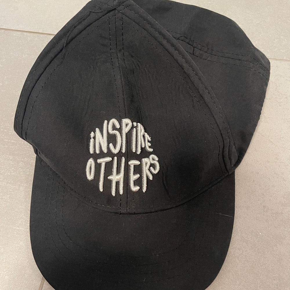 black baseball cap from zara kids with “inspire others” written on it